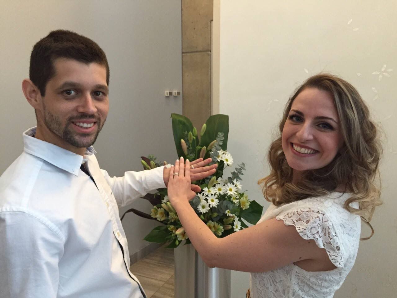 Casal acompanhado por Daiane Justo mostrando as alianças de casamento